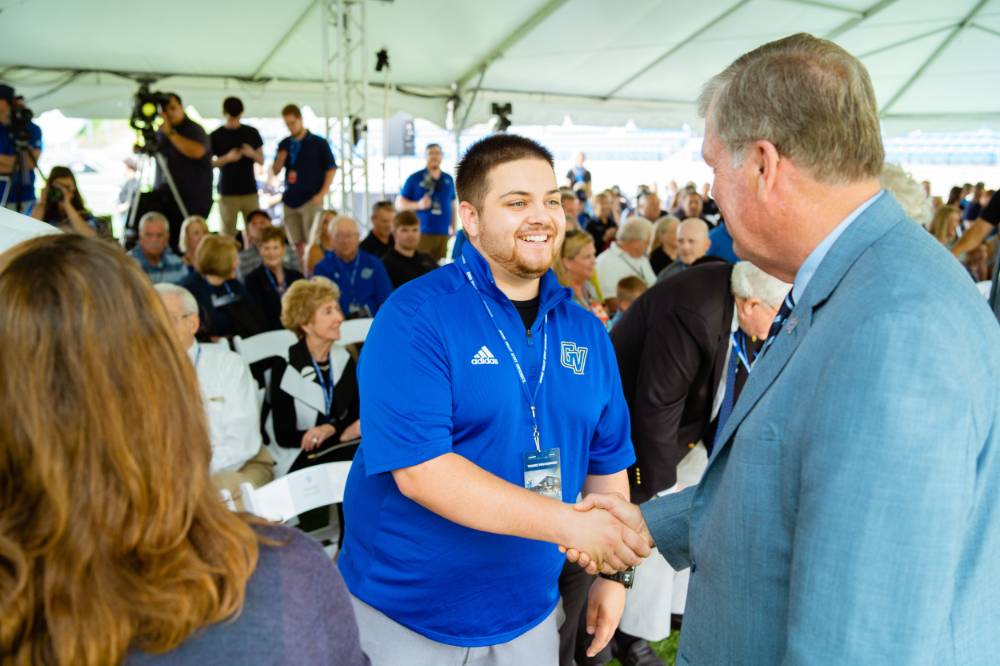 President Haas shaking hands with a guest at the Jamie Hosford Football Center dedication.